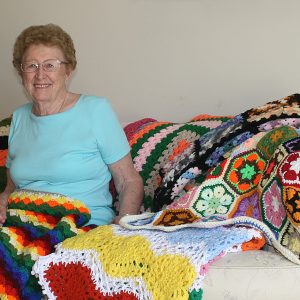 Woman sitting with crotchet blankets