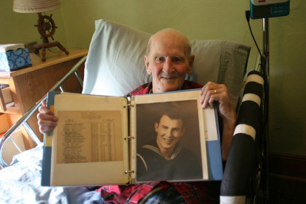 Bob Ellsworth holds up a military picture of himself