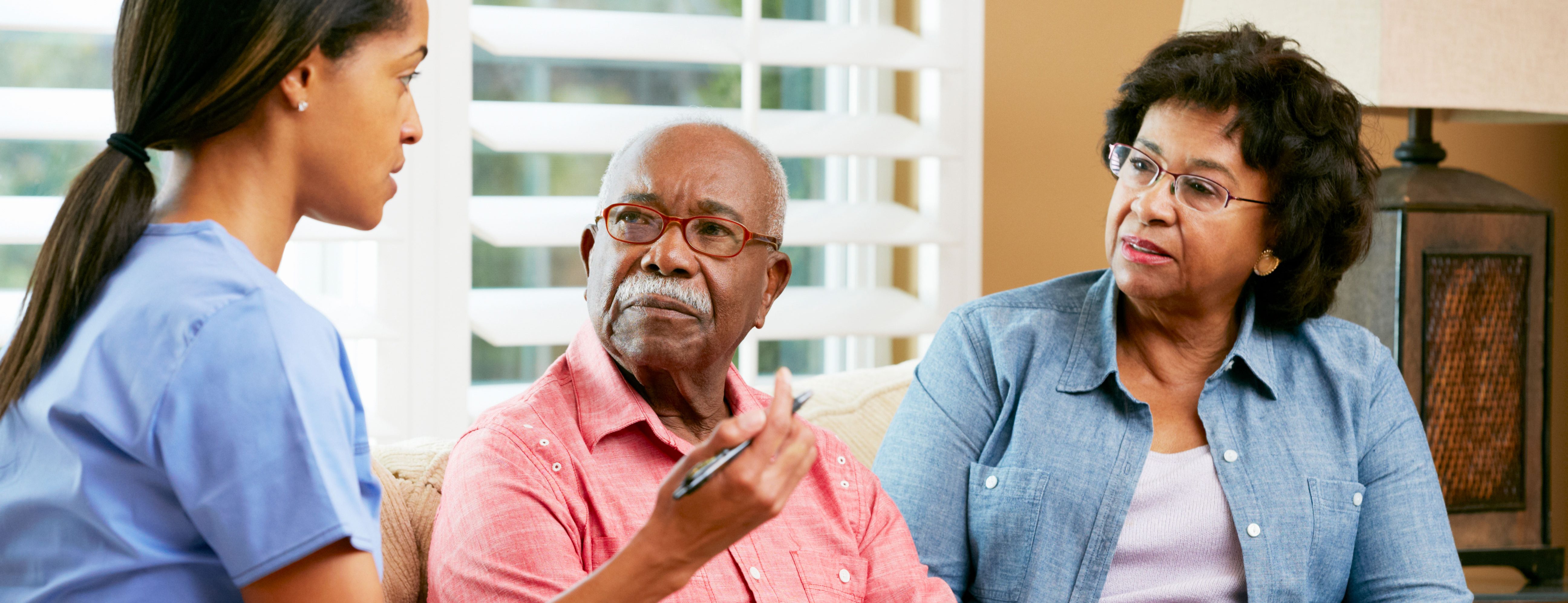 Couple sitting on couch with nurse