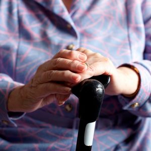 Hands holding onto a walking cane