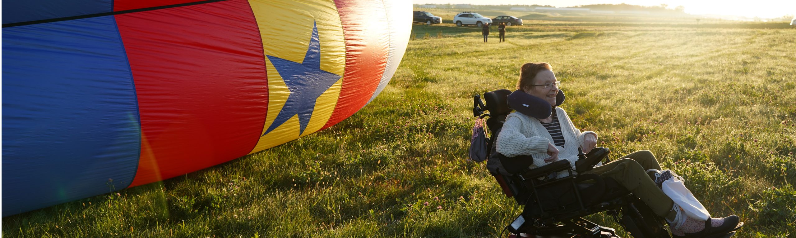 Mary Sluke sitting by a hot air balloon