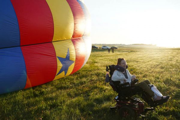 Mary Sluke sitting near a hot air balloon