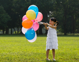 girl holding balloons