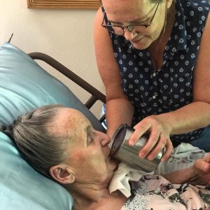 grandma sipping coffee; mom holding the cup to her lips