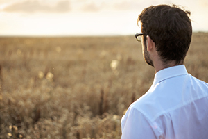 man staring at open field of grass