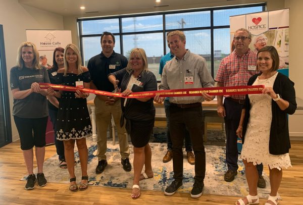 Bismarck office staff cut a ribbon to celebrate the opening of the Bismarck, N.D. office location
