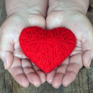 red heart inside palm of hands