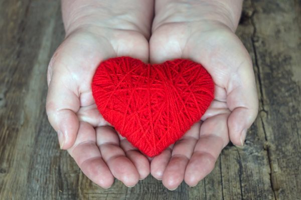 red heart inside palm of hands