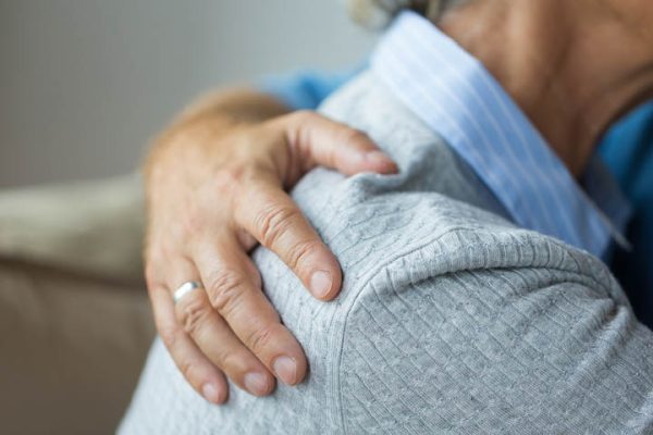 Man's hand on woman's back providing comfort